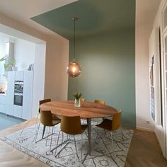 a dining room table with chairs and a rug on the floor in front of it