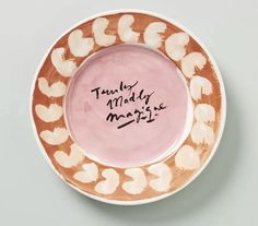 a pink and white plate with writing on the rim that says, family matters are mersi