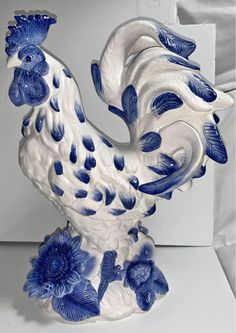 a blue and white rooster statue sitting on top of a table