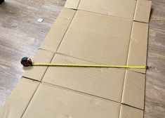 a tape measure is laying on the floor next to some cardboard boxes that have been taped together