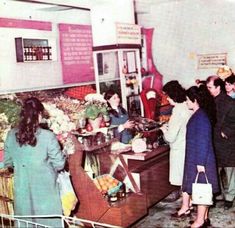 an old photo of people shopping in a store with fruit and veggies on display