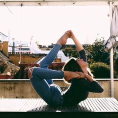 a woman is doing yoga on a deck