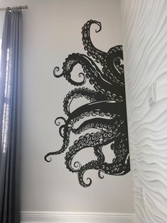 an octopus wall decal on the side of a bed in a room with white walls