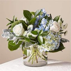 a glass vase filled with blue and white flowers