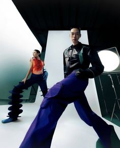 a man and woman are posing in front of a photo studio with their legs spread out