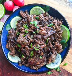 a blue plate topped with meat and limes