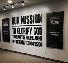 three black and white signs on the wall in a room with carpeted flooring