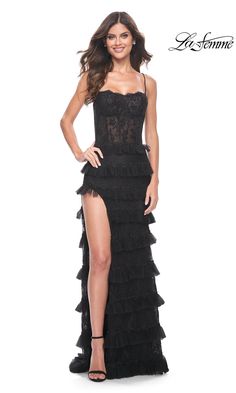 From La Femme, this long black ruffled prom dress 32113 is well-suited for the girl who loves a truly unique look. With a sheer floral-lace bodice that wraps around to the lace-up back, this long tiered long black designer dress gets a fitted look for prom, galas, and other red-carpet events. The long black formal dress is nothing short of fabulous with the true star of the show being the long ruffled skirt that opens in a side slit before flowing to the floor in eye-catching tiers. The girl who Ruffled Prom Dress, Long Ruffled Skirt, Long Black Dress Formal, Straight Across Neckline, Prom Dress Stores, Black Dress Formal, Black Prom, Prom Dresses Lace