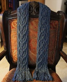 two blue knitted scarfs sitting on top of a chair