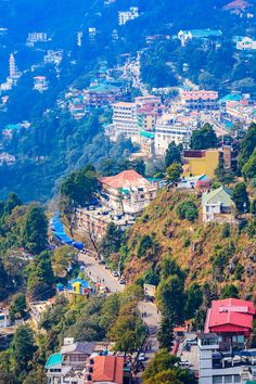 an aerial view of a city on a hill with lots of trees and buildings in the background