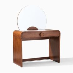 a wooden table with a mirror on it and a shelf underneath the mirror that holds a circular object