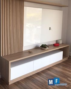 an empty room with a large white shelf and wooden blinds on the window sill