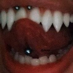 an open mouth with white teeth and red tongue