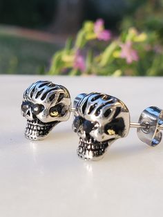 Description: Embrace a rebellious and edgy style with these Stainless Steel Black Cz Girls Biker Skull Stud Earrings. Crafted for those who love to make a statement, these earrings bring together toughness and glamour in a unique design. Product Features: Stainless Steel Construction: The earrings are made from durable stainless steel, ensuring longevity and resistance to tarnish. Black Cubic Zirconia Accents: The black cubic zirconia stones add a touch of darkness and sparkle, creating a bold and distinctive look. Biker Skull Design: The skull motif gives these earrings a rebellious and biker-inspired aesthetic, perfect for those with a daring sense of style. Stud Style: The stud design makes these earrings easy to wear daily, adding a hint of attitude to your look. Versatile Accessory: W Touch Of Darkness, Stud Design, Inspired Aesthetic, Stud Style, Edgy Style, Skull Design, Design Product, Steel Construction, Edgy Fashion