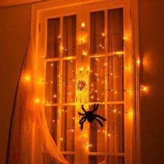 a window decorated with fairy lights and a stuffed animal