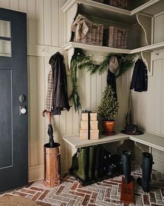 a coat rack with umbrellas, boots and other items on it next to a door