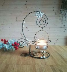 a candle holder with two stars on it and a christmas decoration next to it in front of a wooden wall