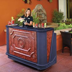 a woman standing behind a bar with drinks on it