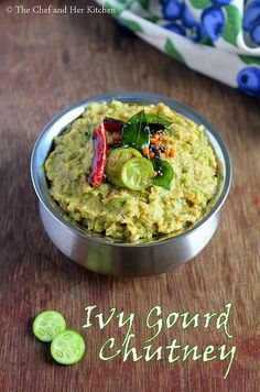 a metal bowl filled with guacamole on top of a wooden table