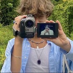 a woman holding up a camera in front of her face