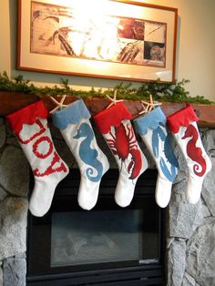 christmas stockings hanging from a mantel in front of a fireplace