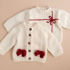 two knitted sweaters with bows on the front and back, both in white