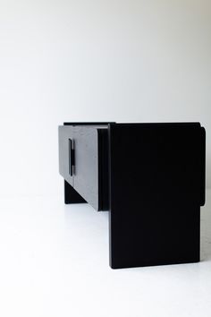 a black cabinet sitting on top of a white floor