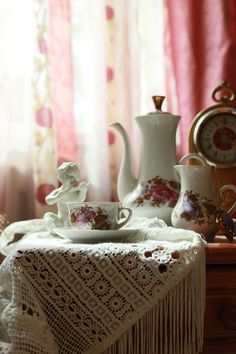 a table topped with plates and cups next to a window