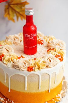 a cake with icing on it and a bottle of booze sitting on top