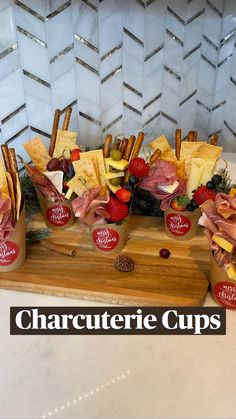 an assortment of cheeses and meats on a cutting board with the words charcuterie cups above it