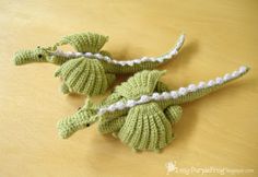 two crocheted seahorses sitting on top of a wooden table