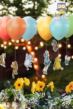 a bunch of balloons that are in the air with some flowers and lights behind them