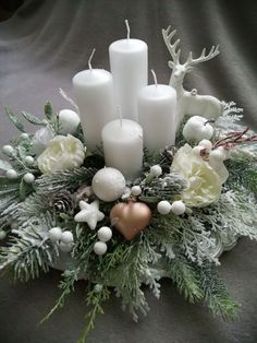 a centerpiece with candles, flowers and other decorations on it's table top