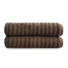 two brown towels folded on top of each other in front of a white background,