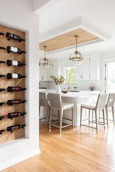 a wine rack in the middle of a kitchen next to a dining room table and chairs