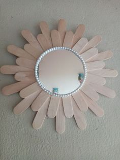 a mirror that is on the wall with some kind of decoration in front of it