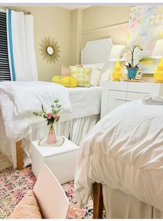 two beds in a room with yellow and white decor