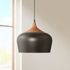 a black and wood light hanging from a ceiling fixture in a room with windows behind it