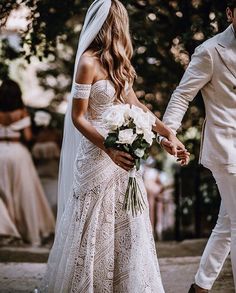 the bride and groom are holding hands