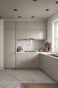 a kitchen with white cabinets and marble counter tops