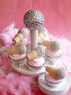 cupcakes and ice cream cones are arranged in a cone with pink icing