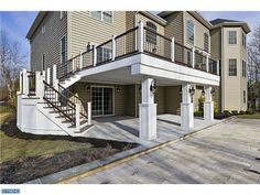 an image of a two story house with white railings and balconies on the second floor