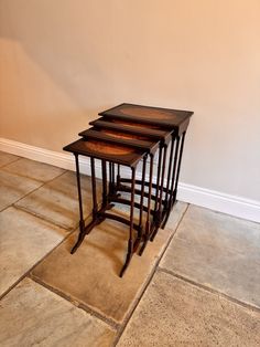 three wooden tables stacked on top of each other in a room with tile flooring