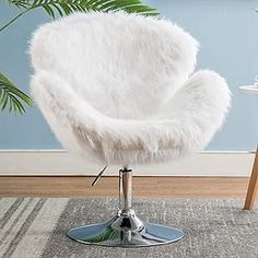 a white chair sitting on top of a carpet covered floor next to a potted plant