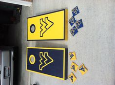 two cornhole game boards, one with west virginia university symbols