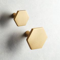 two wooden hexagonal knobs on a white wall