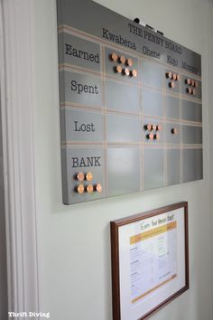 a bulletin board hanging on the wall next to a framed bank notepad and pen