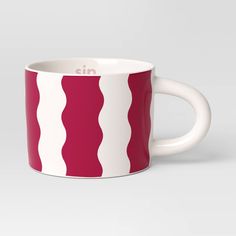 a red and white coffee mug with the word nin on it's side