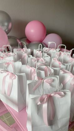 pink and white bags with bows on them are sitting in the middle of a table