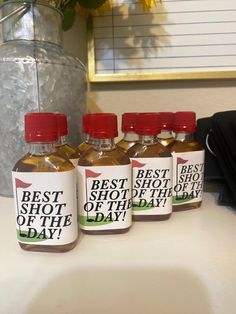 four bottles of best shot of the day sitting on a counter